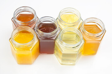 Hexagonal jars with different types and colors of fresh flower honey. vitamin food for health and life