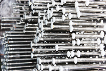 Close-up of nails, metal sheet with nails Nails texture background hammered into metal. Hats with nails. abstraction, steel self-tapping screws, metal screw, iron screw, screws as a background