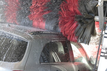 auto in waschanlage mit wasser und schaum softbürste waschen