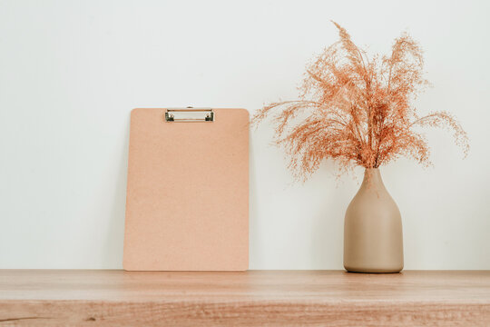 Empty wooden clipboard and dried flowers pampas grass