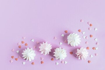 Obraz na płótnie Canvas White marshmallows with decorations on a violet pastel background.