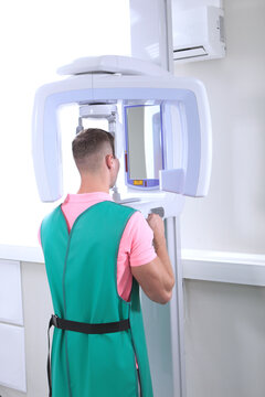 Modern dentistry. A patient in a modern dental clinic takes a panoramic picture of the teeth. Prevention of dental diseases. Accurate diagnosis.Back view.