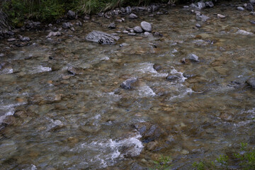 Closeup view of the fresh water stream with a rocky bed.	