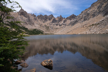 The alps. View of Toncek lake at the top of Catedral hill in Bariloche, Patagonia Argentina. The rocky mountains and sky reflection in the water. 