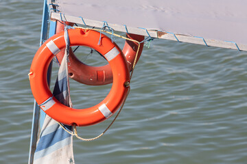 close-up lifebuoy on a boat. Red lifebuoy on ship railing with sea surface