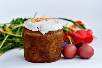 Easter cake and red tulips on white.