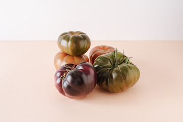 Tomatoes of different varieties and different colors. On a warm colored background, isolated. Close up. Still life.