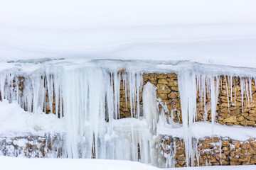 Gabion structures on the mountain slopes along the road covered with snow.