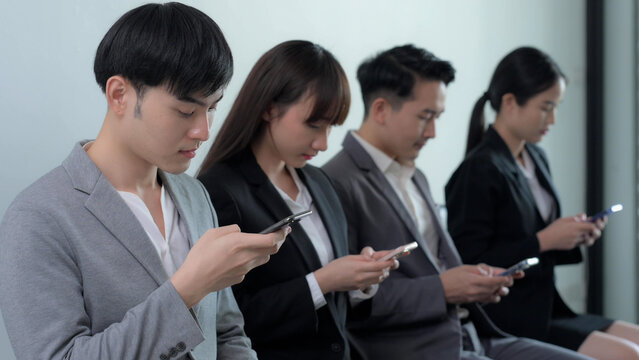 Group of Asian businessman and businesswoman watching smart mobile phones, Startup business teenagers using social media in the office, Social addict concept