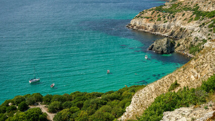Obraz premium Yachts stand in a bay with azure water near Cape Fiolent