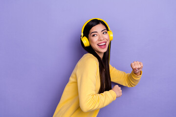 Profile side photo of young cheerful girl have fun dance clubber meloman look empty space isolated over purple color background