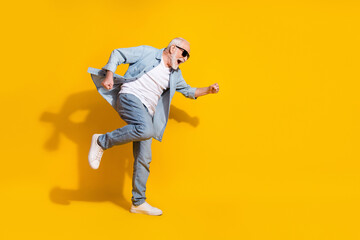 Full length body size view of attractive cheerful crazy grey-haired man having fun great success isolated on bright yellow color background