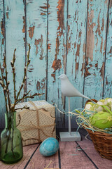 Moscow, Russia, February 2022, spring Easter still life, blue bird figurine, Easter eggs on bird...