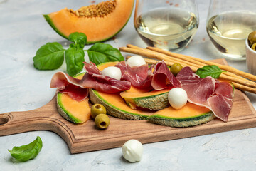 Italian traditional appetizer Prosciutto con Melone, mozzarelle and basilico. Cantaloupe melon with...