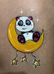 the panda character sits on a yellow moon with stars and smiles. cartoon  hand drawing  on  beige background