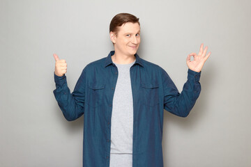 Portrait of happy mature man showing okay and thumb up gestures