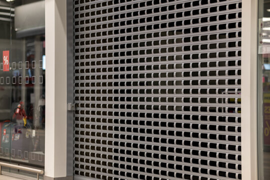 closed market. Lowered door grille with lock. Beige metal lattice door.