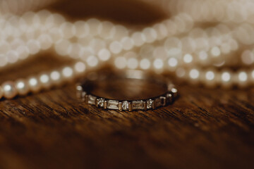 Bague sertie de diamants et collier de perles en arrière-plan