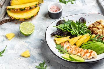 Grilled chicken breast, pineapple, avocado, green rocket salad, lime and olive oil. Healthy juicy food. banner, menu recipe place for text, top view
