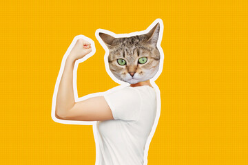 Strong woman headed by cat head raises arm and shows bicep isolated on a color yellow background....