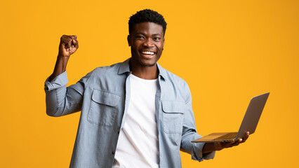 Happy african american guy holding laptop and gesturing