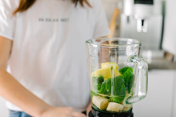 Process of preparing green detox smoothie with blender. Vegan drinks. Concept of detox, dieting