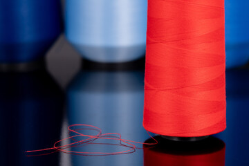 red sewing thread standing in an isolated environment