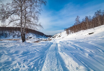 Winter landscape with trees and sky from the high rocky river bank