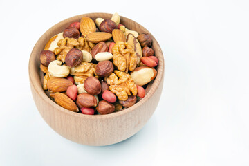 assortment of nuts in a wooden plate on a white background. vitamin organic food