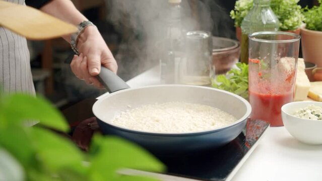 Unrecognizable cook preparing risotto in pan