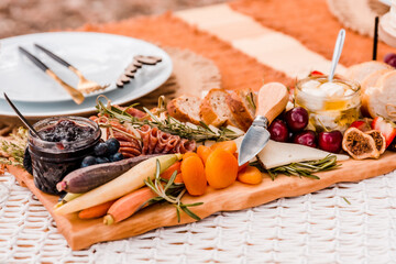 Charcuterie picnic spread on wooden board closeup details