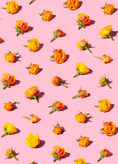 Red and yellow summer flowers on a pink pastel background. MInimal flat lay design.