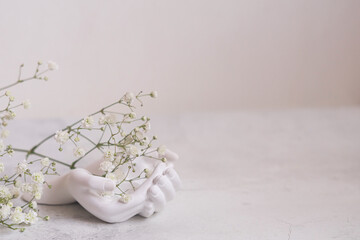 Hands of ceramist holds Gypsophila. Spring is coming concept.