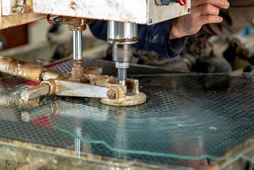 Glass processing. Drilling machine for making holes in tempered glass. The cutter makes a hole in the glass.