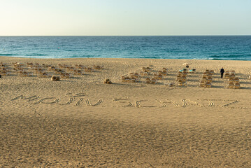 Fototapeta na wymiar Sun loungers on a deserted sandy beach 