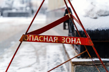 Red metal fencing with inscription in Russian language Danger Zone