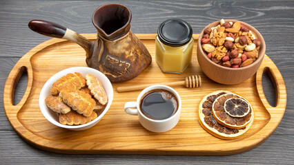 fresh hot coffee with turkey and dried citrus and honeycomb on a kitchen wooden board. useful vitamin food for the human body