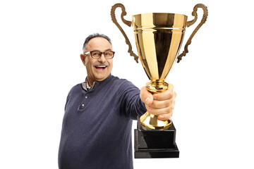 Happy mature man holding a gold trophy cup in front of camera