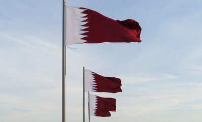 many qatar flags flying high in the wind.