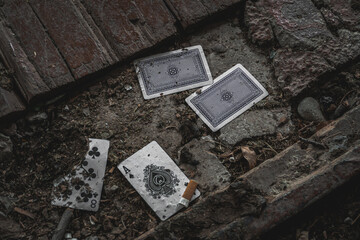 Playing cards thrown on dirty abandoned place.