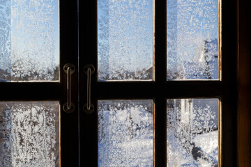Melting ice running down a window pane,