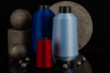 blue sewing thread standing on decorative stones in an isolated setting