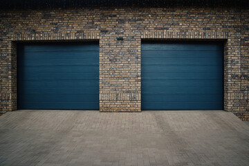 Garage Door. A double garage with blue doors at the end of a driveway