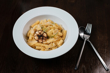 Pasta with herbs. Traditional Italian dish served on restaurant table.