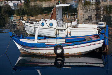 Fototapeta na wymiar Fishing boats with motor and oars, moored in a small port of a fishing village