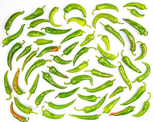 green hot peppers evenly spread on a white background. vitamin vegetables for health