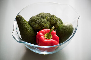 Pepper, broccoli and avocado in a glass vase - the idea of healthy fresh food 