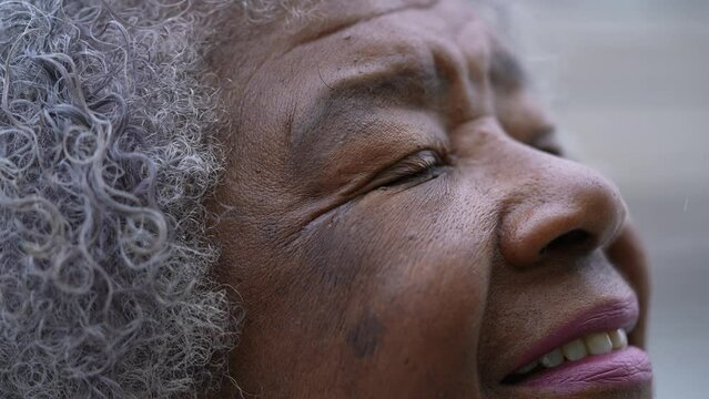 A meditative older woman closing eyes in contemplation