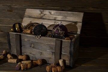 Wooden antique box with wine corks and Christmas tree toys. Photo in a low key.