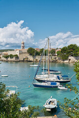 Boote im Hafen der Stadt Krk an der Adria in Kroatien. Im Hintergrund die historische Altstadt - 486118532